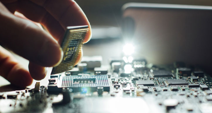 Hand picking up component from circuit board