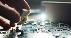 Hand picking up component from circuit board Hand picking up component from circuit board