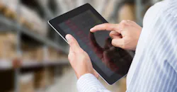 Businessman checking inventory in stock room on touchscreen tablet Businessman checking inventory in stock room on touchscreen tablet